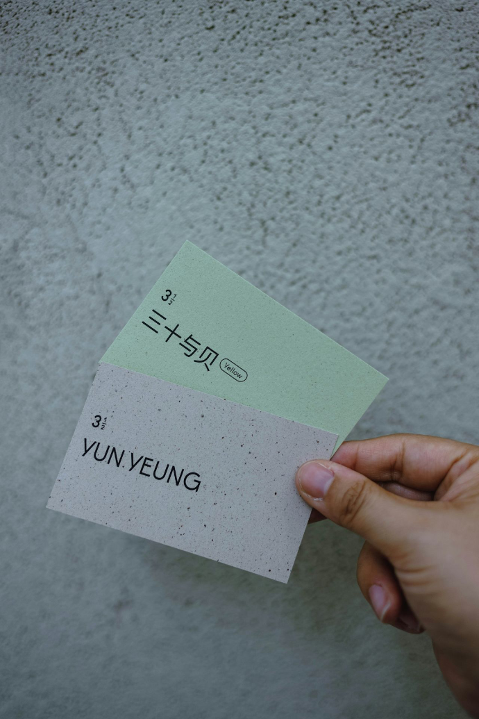 Hand holds two textured cards with text.